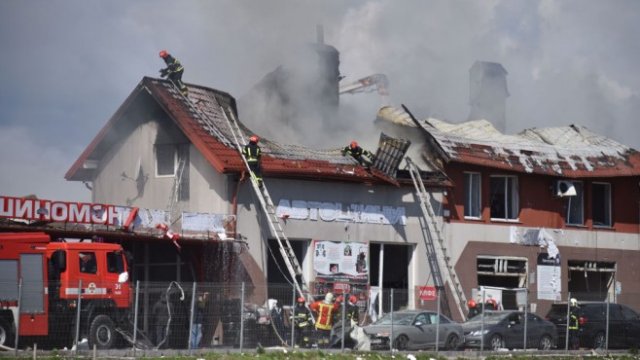 <p>
	<em>Пожарникари гасят огън в сервиз за коли след удар на руски ракети в Лвов. Снимка: Pavlo Palamarchuk/Getty Images</em></p>
