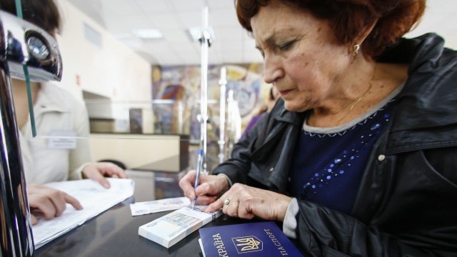<p>
	Жена получава пенсията си в рубли в пощата на Симферопол. <em>Снимка: Ройтерс</em></p>
