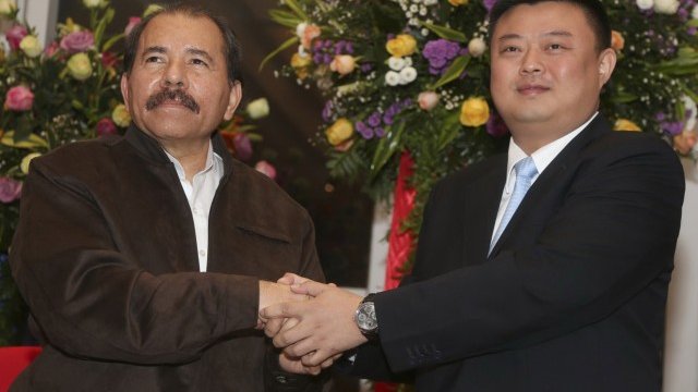 <p style="text-align: justify;">
	Президентът на Никарагуа Даниел Ортега и директорът на HKND Group Уан Дзин си стискат ръцете след подписаното на 14 юни 2013 г. споразумение за изграждане на канал през Никарагуа. <em>Снимка: Ройтерс</em></p>
