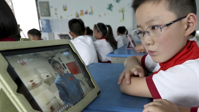 <p>
	Китайски ученик гледа видео с учебна цел на училищен iPad. <em>Снимка: Ройтерс</em></p>
