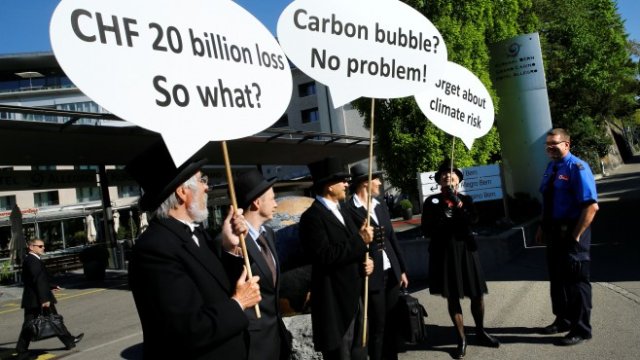 <p>
	Протестиращи, които демонстрират липсата на инвестиции в изменението на климата, държат банери пред годишното Общо събрание на Швейцарската национална банка в Берн, Швейцария, 27 април 2018. Снимка: Ройтерс</p>
