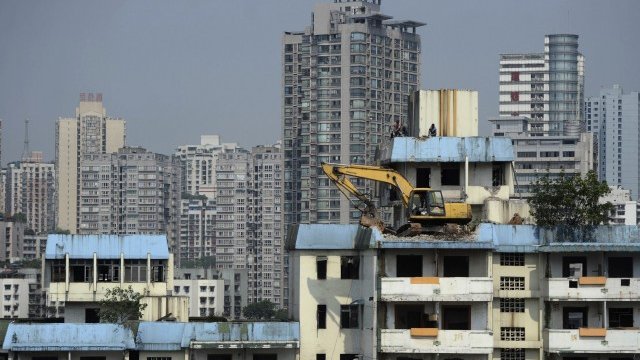 <p style="margin-bottom: 0cm">
	Багер разчиства стара сграда до жилищен комплекс в Чунцин.&nbsp;<em>Снимка: Ройтерс</em></p>
