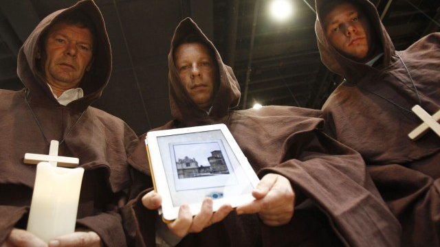 <p>
	Служители на германското издателство Luebbe Digital, облечени като монаси с iPad, демонстрират новия интерактивен роман &quot;Апокалипсис&quot; на книжния пазар по време на&nbsp;Франкфуртския книжен панаир. <em>Снимка: Ройтерс</em></p>
