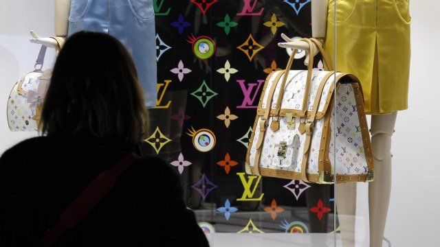 <p>
	Ценителка на лукса пред витрина с чанта на Louis Vuitton. <em>Снимка: Ройтерс</em></p>
<div>
	&nbsp;</div>
