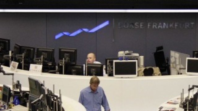 <p>
	Трейдъри на борсата във Франкфурт пред графиката на DAX. Снимка: Ройтерс</p>
