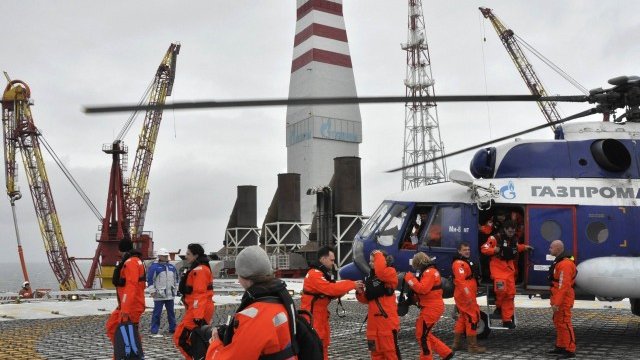 <p>
	Журналисти слизат от хеликоптер на петролна платформа в находището Приразломное в Арктика. Газпром Нефт ще запази производствените си планове за Приразломное въпреки западните санкции, заявиха от компанията. <em>Снимка: Ройтерс</em></p>
