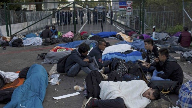 <p>
	Мигранти почиват пред ограда на път към Унгария, след като Унгария затвори границата със Сърбия. <em>Снимка: Ройтерс</em></p>
