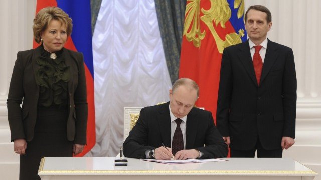 <p style="margin-bottom: 0cm">
	Путин подписва закона за ратифициране на договора за приемане на Крим и Севастопол в Руската федерация. <em>Снимка: Ройтерс</em></p>
