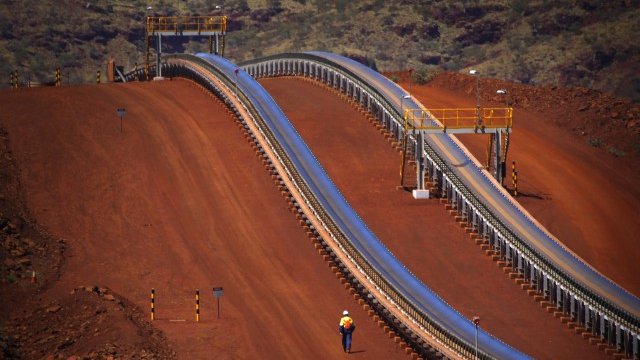 <p>
	Работник минава край конвейер от мина на Rio Tinto в Австралия. <em>Снимка: Ройтерс</em></p>
