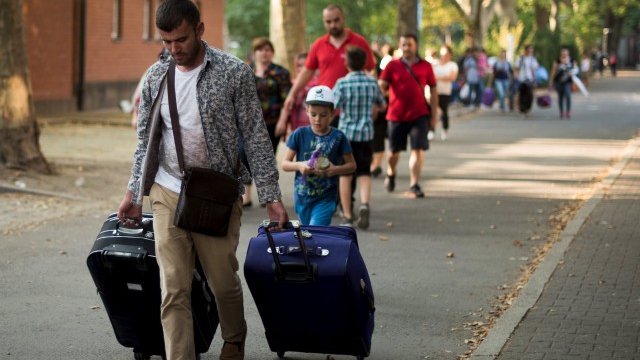 <p>
	Сирийски бежанци напускат временен лагер за настаняване в Берлин. <em>Снимка: Ройтерс</em></p>
