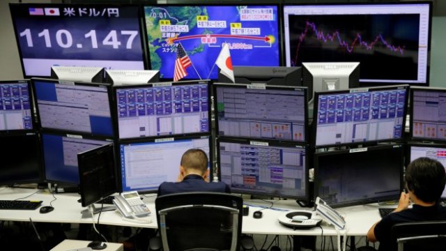 <p>
	Валутни дилъри в Токио. <em>Снимка: Ройтерс</em></p>
