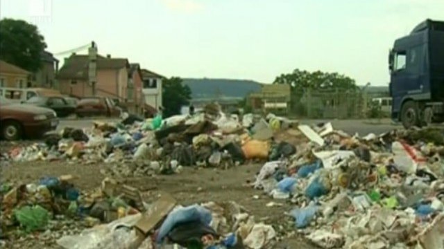 <p>
	<em>Камиони, натоварени с жито, чакат покрай натрупаните боклуци. Кадър: БНТ</em></p>
