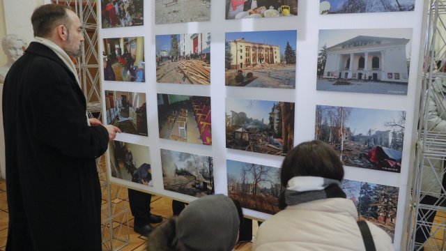 Хора посещават фотоизложбата &bdquo;Театърът - душата на Мариупол&quot; по повод първата годишнина от бомбардировката на Мариуполския драматичен театър в Драматичния театър &quot;Иван Франко&quot; в Киев. Снимка: EPA/SERGEY DOLZHENKO