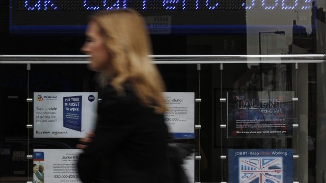 <p>
	Британка минава край бюро за наемане на служители в Лондон. <em>Снимка: Ройтерс</em></p>

