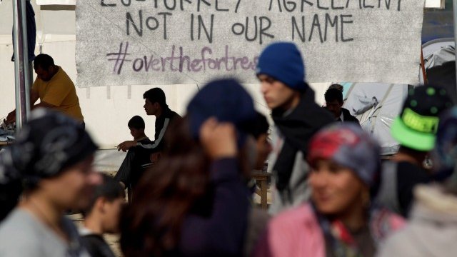 <p>
	Бежанци и мигранти си проправят пътя под лозунг в лагера на гръцко-македонската граница близо до село Идомени. <em>Снимка: Ройтерс</em></p>
