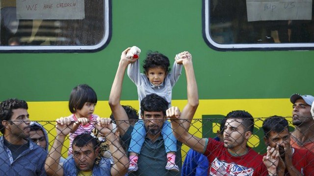 <p>
	Стотици мигранти, много от тях бежанци от войната в Сирия, прекараха нощта в претъпкан влак на гара в Унгария, отказвайки да отидат в лагер за бежанци наблизо. <em>Снимка: Ройтерс</em></p>
