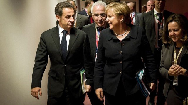 <p>
	Френският президент Никола Саркози и германският канцлер Ангела Меркел пристигат на срещата на върха. Снимка: Ройтерс</p>
