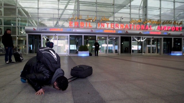 <p>
	Иракски бежанец, завърнал се от Германия, целува пода на летището в Ербил. <em>Снимка: Ройтерс</em></p>
