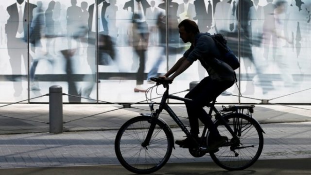 <p>
	Мъж преминава на колело пред сградата на ЕК в Брюксел, Белгия. <em>Снимка: Архив Ройтерс</em></p>
