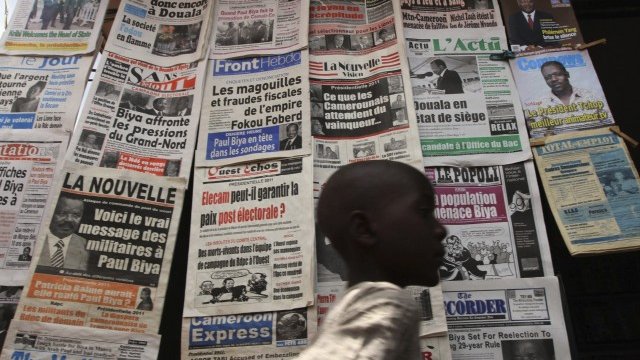 <p>
	Дете минава покрай вестникарска сергия в Яунде, Камерун. В развиващите се пазари вестникарите отчитат ръст. <em>Снимка: Ройтерс</em></p>
