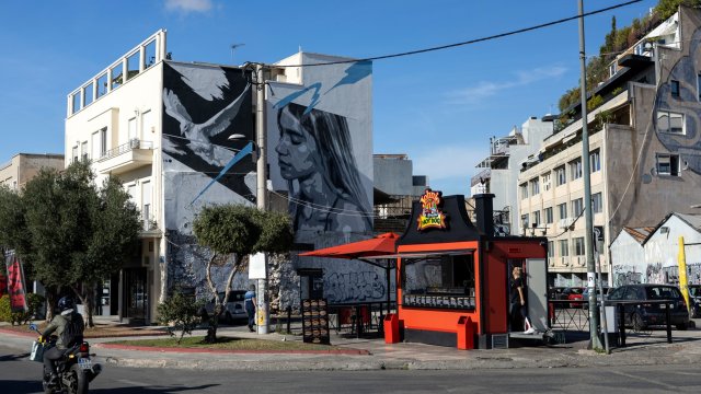 Будка за хот-дог до жилищни сгради в квартал &quot;Гази&quot; в Атина. Снимка: Yorgos Karahalis/Bloomberg