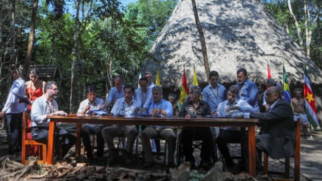 <p>
	Правителствените представители на страните от региона се събраха в традиционна колиба на коренните общности в джунглата. Снимка: Ройтерс</p>
