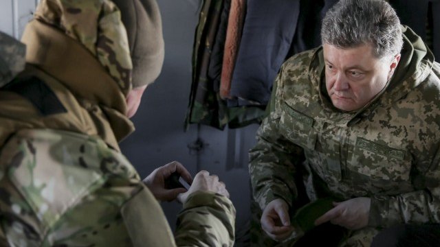 <div>
	Украинският президент Порошенко разговаря с началникa на генералния щаб на украйнските въоръжени сили Виктор Муженко на борда на хеликоптер. <em>Снимка: Ройтерс</em></div>
