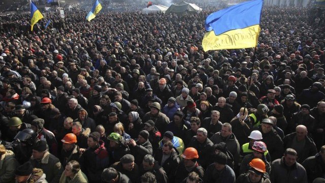 <p style="margin-bottom: 0cm">
	Демонстранти слушат служители на полицията, присъединили се към протестите в Киев. <em>Снимка: Ройтерс</em></p>
