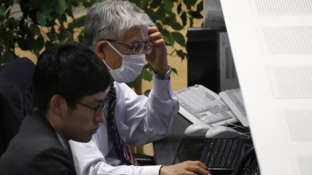 <p>
	Трейдъри на фондовата борса в Токио във вторник. <em>Снимка: Архив Ройтерс</em></p>
