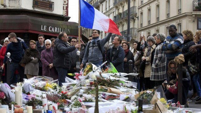 <p>
	Хиляди отдават почтит пред жертвите в един от ресторантите в Париж. <em>Снимка: Ройтерс</em></p>
