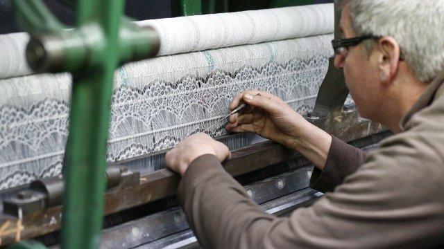 <p style="margin-bottom: 0cm; line-height: 100%">
	Служител инспектира нишките на механичната машина за дантели във фабриката Desseilles Laces в Кале. <em>Снимка: Ройтерс</em></p>
