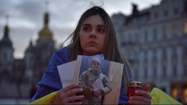 Светлана носи портрет на загиналия край Мариопул неин съпруг. Снимка:  EPA/OLEG PETRASYUK