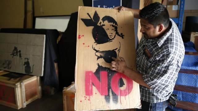 <p>
	Творба на графити художника Banksy.<em> Снимка: архив Ройтерс</em></p>
