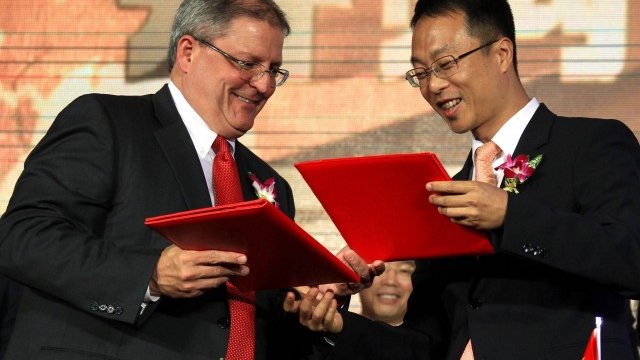 <p>
	Главният изпълнителен директор на AMC Entertainment Джери Лопез (л) след подписването на договора с вицепрезидента на Wanda Group Джан Лин. <em>Снимка: Ройтерс</em></p>
