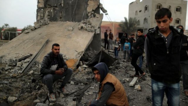 <p>
	Палестинци в останките на сграда, унищожена от израелски въздушни удари в южната част на ивицата Газа. <em>Снимка: Ройтерс</em></p>
