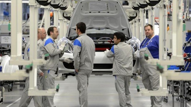 <p>
	Работници в завода на Volkswagen в Оснабрюк пред производствена линия на Porsche Boxter. <em>Снимка: Архив Ройтерс</em></p>
