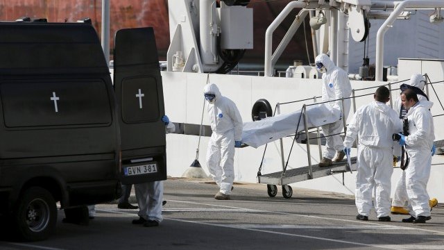 <p>
	Италиански служители пренасят телата за загинали имигранти след корабокрушението в неделя, при което загинаха около 700 души. <em>Снимка: Ройтерс</em></p>
