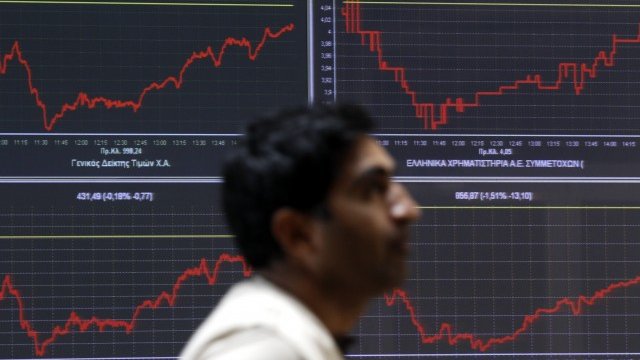 <p>
	Грък минава покрай табло, отразяващо движението на индексите на фондовата борса в Атина. <em>Снимка: Архив Ройтерс</em></p>
