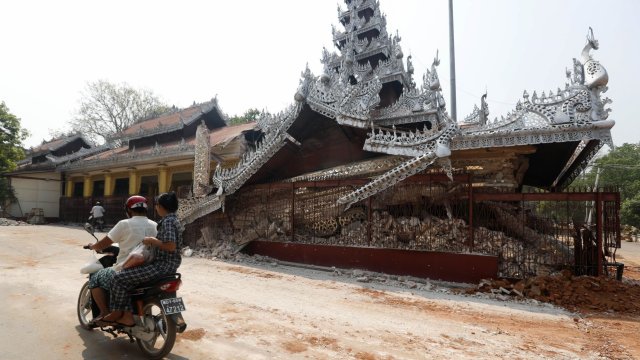 Мотоциклетист минава покрай срутена пагода в Мандалай, Мианмар. Снимка: EPA/NYEIN CHAN NAING