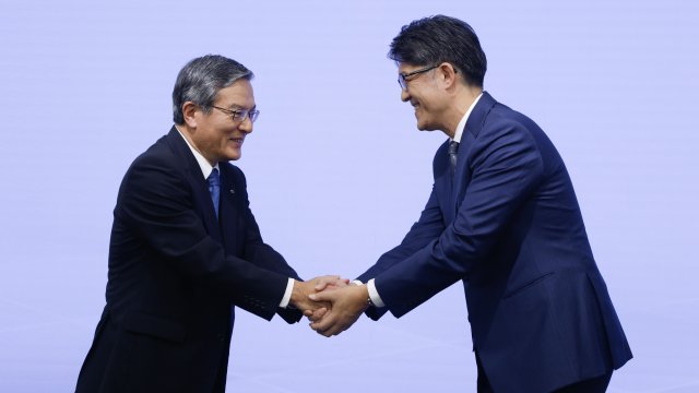 Изпълнителният директор на Nippon Telegraph &amp; Telephone Акира Шимада (вляво) и ръководителят на Toyota Коджи Сато (вдясно) при обявяването на партньорството в Токио. Снимка: Bloomberg L.P.