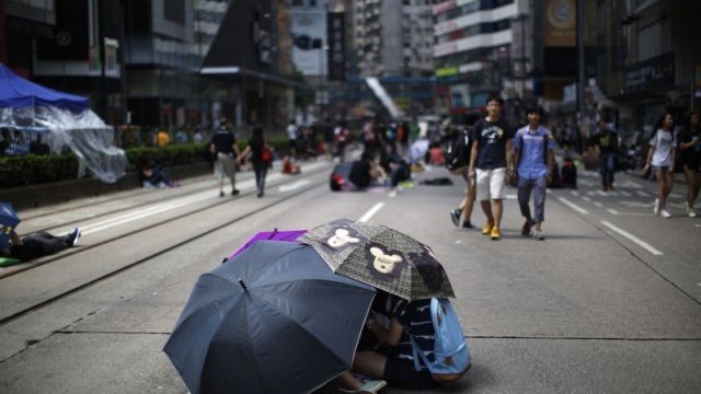 <p>
	&quot;Революцията на чадърите&quot; - чадърът се превърна в символ на убежище за протестиращите граждани. <em>Снимка: Ройтерс</em></p>
