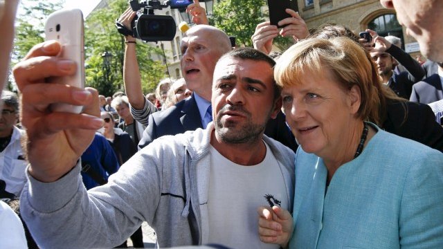 <p>
	Бежанец от Сирия си прави селфи с канцлера. <em>Снимка: Ройтерс</em></p>
