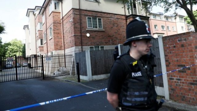 <p>
	Полиция охранява жилищна сграда в южен Манчестър заради ареста. <em>Снимка: Ройтерс</em></p>
