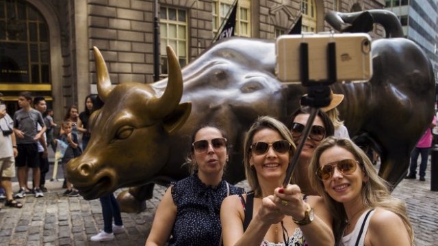 <p>
	Туристи пред фондовата борса в Ню Йорк. <em>Снимка: Ройтерс</em></p>
