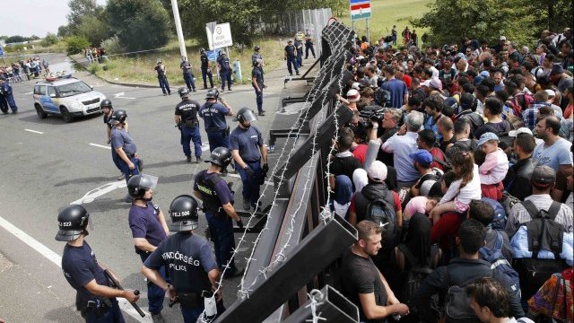 <p>
	Стотици мигранти напираха да преминат през загражденията, издигнати от унгарската полиция на главния път, свързващ Сърбия и Унгария. <em>Снимка: Ройтерс</em></p>
