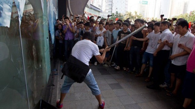 <p>
	Протестиращи в Китай разрушават фасадата на японски мол. <em>Снимка: Ройтерс</em></p>
