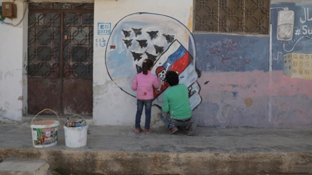 <p>
	Сирийският художник Азиз ал-Асмар работи върху графити надпис, свързан с войната в Украйна на стена в Идлиб. <em>Снимка: EPA/YAHYA NEMAH ATTENTION</em></p>
