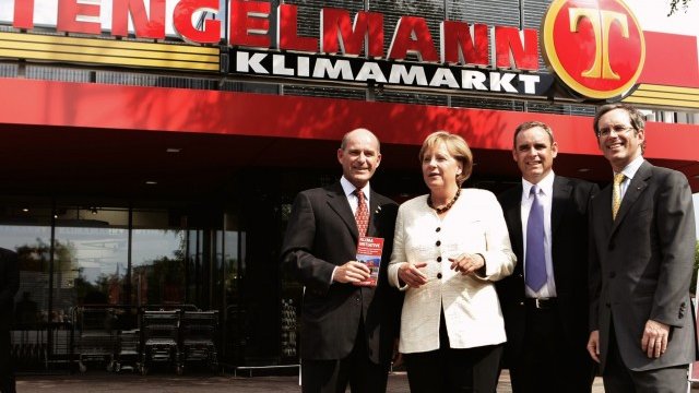 <p>
	<span style="font-size: 11.8181819915771px;">Братята Карл-Еривиан, Георг и Кристиян Хауб (отляво надясно) позират пред магазин на Tengelmann в Мюлхайм с германския канцлер Ангела Меркел през август 2009 г. <em>Снимка: архив Ройтерс</em></span></p>
