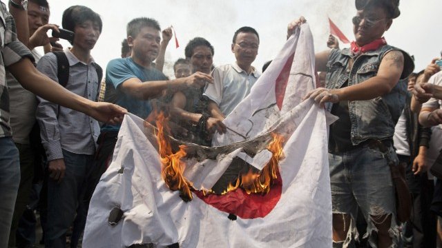 <p>
	Китайци горят японското знаме в Ханджоу. <em>Снимка: Ройтерс</em></p>
