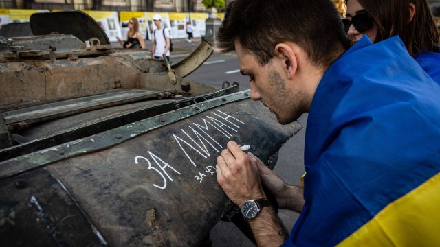 Саша (22 г.) от Лиман, Донбас, пише надпис върху разрушен руски танк в Киев. Снимка: Alex Chan Tsz Yuk/SOPA Images/LightRocket via Getty Images